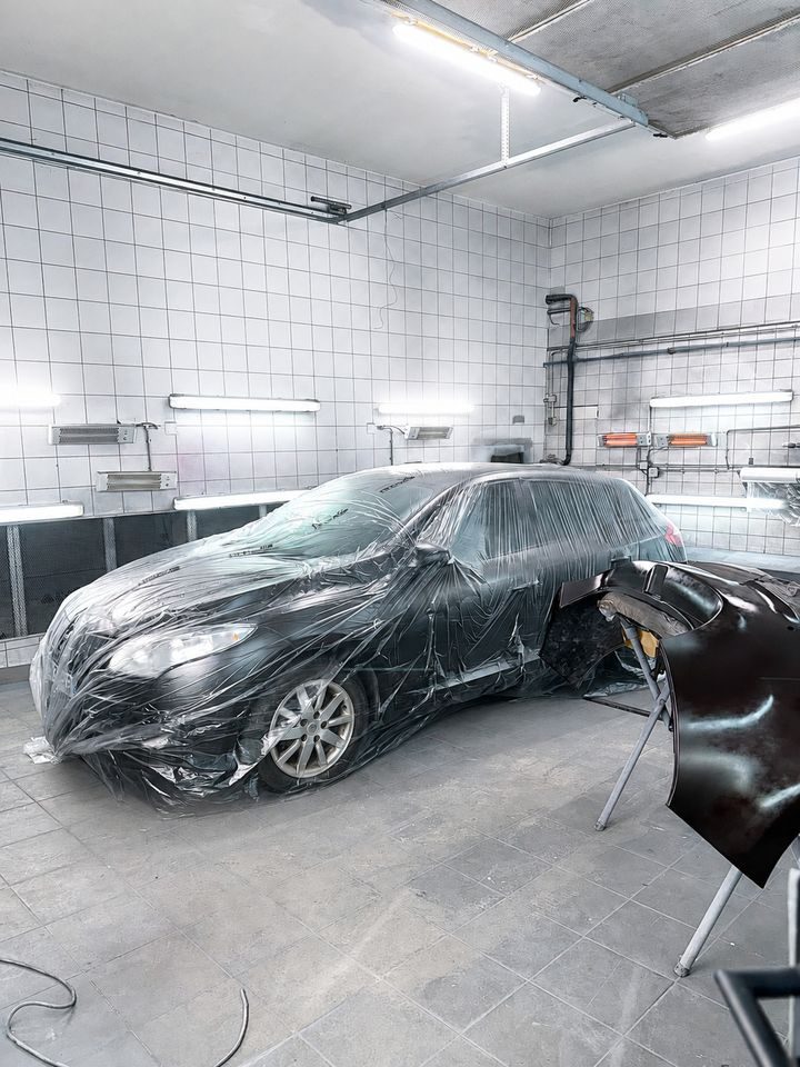 Une voiture protégée en cabine de peinture
